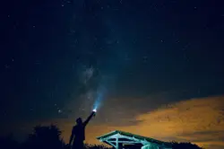Man holding flashlight outdoor during nighttime
