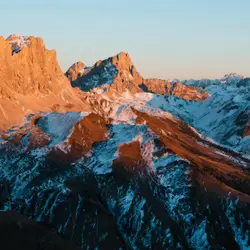 Snow capped mountains glow in the morning light.
