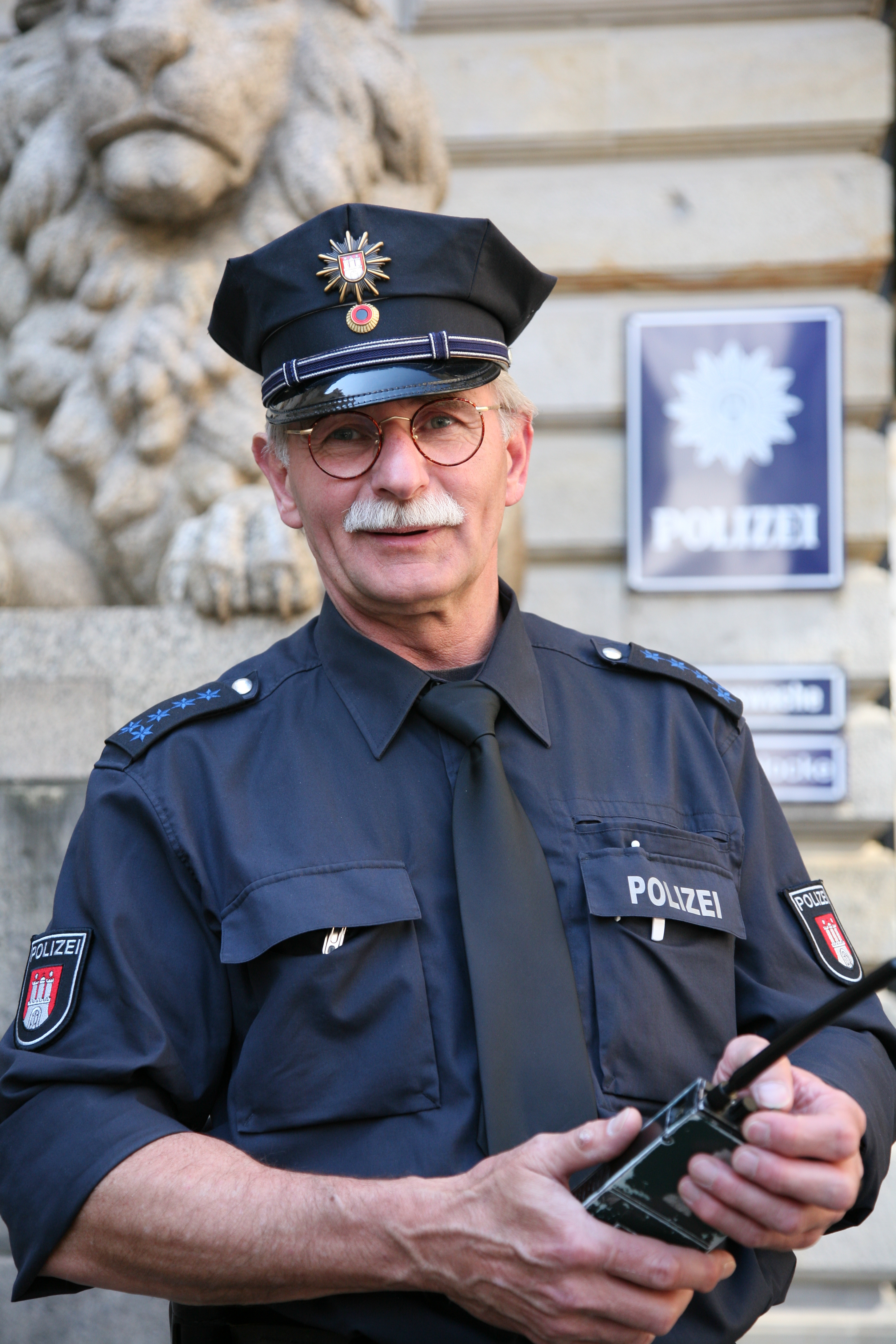 Man In A Uniform Is Holding A Cell Phone