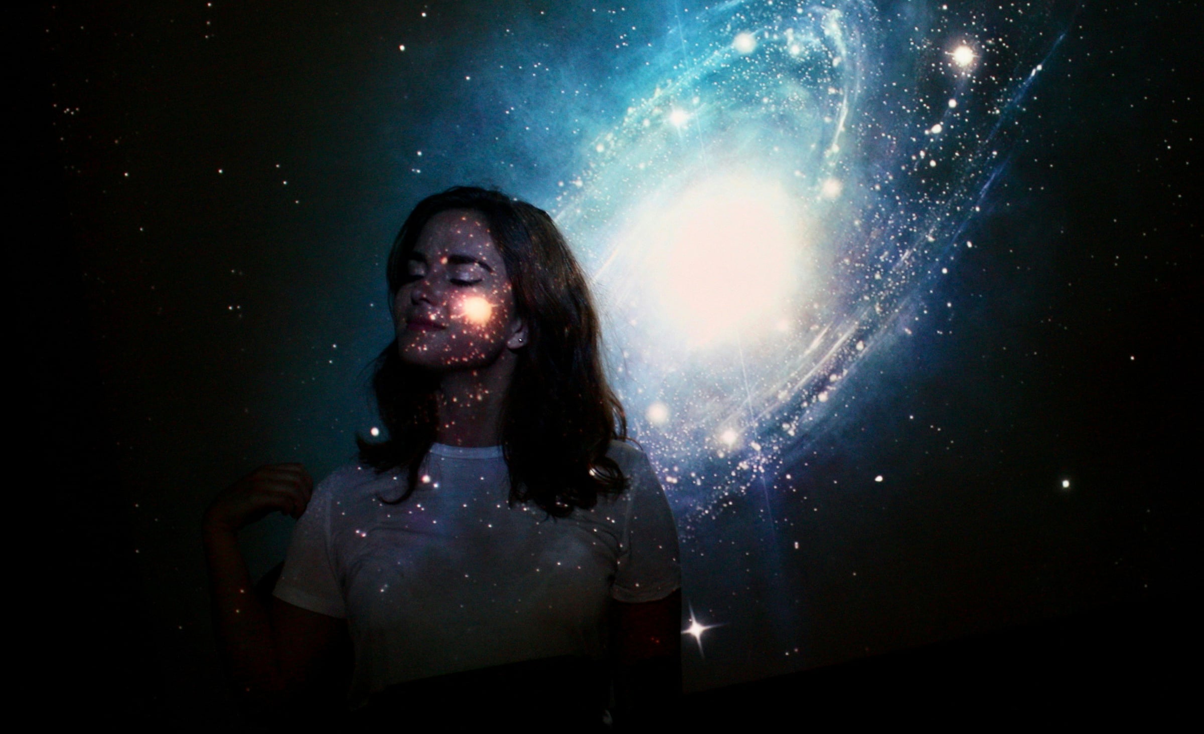 Woman Standing In A Dark Room With A Cell Phone