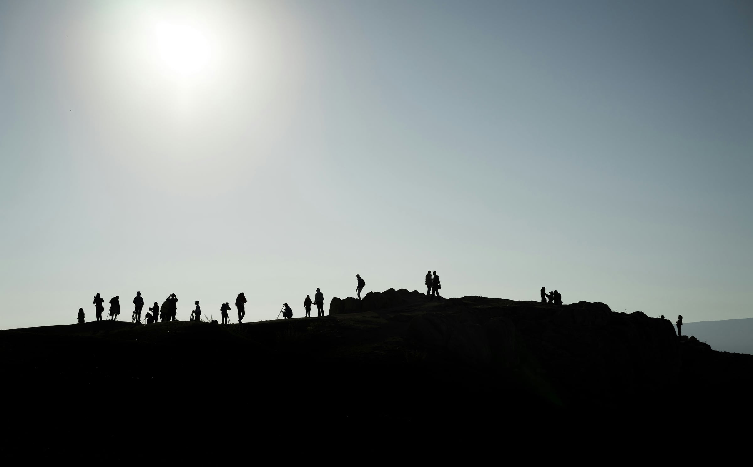 People Standing On A Hill Overlooking A Beach